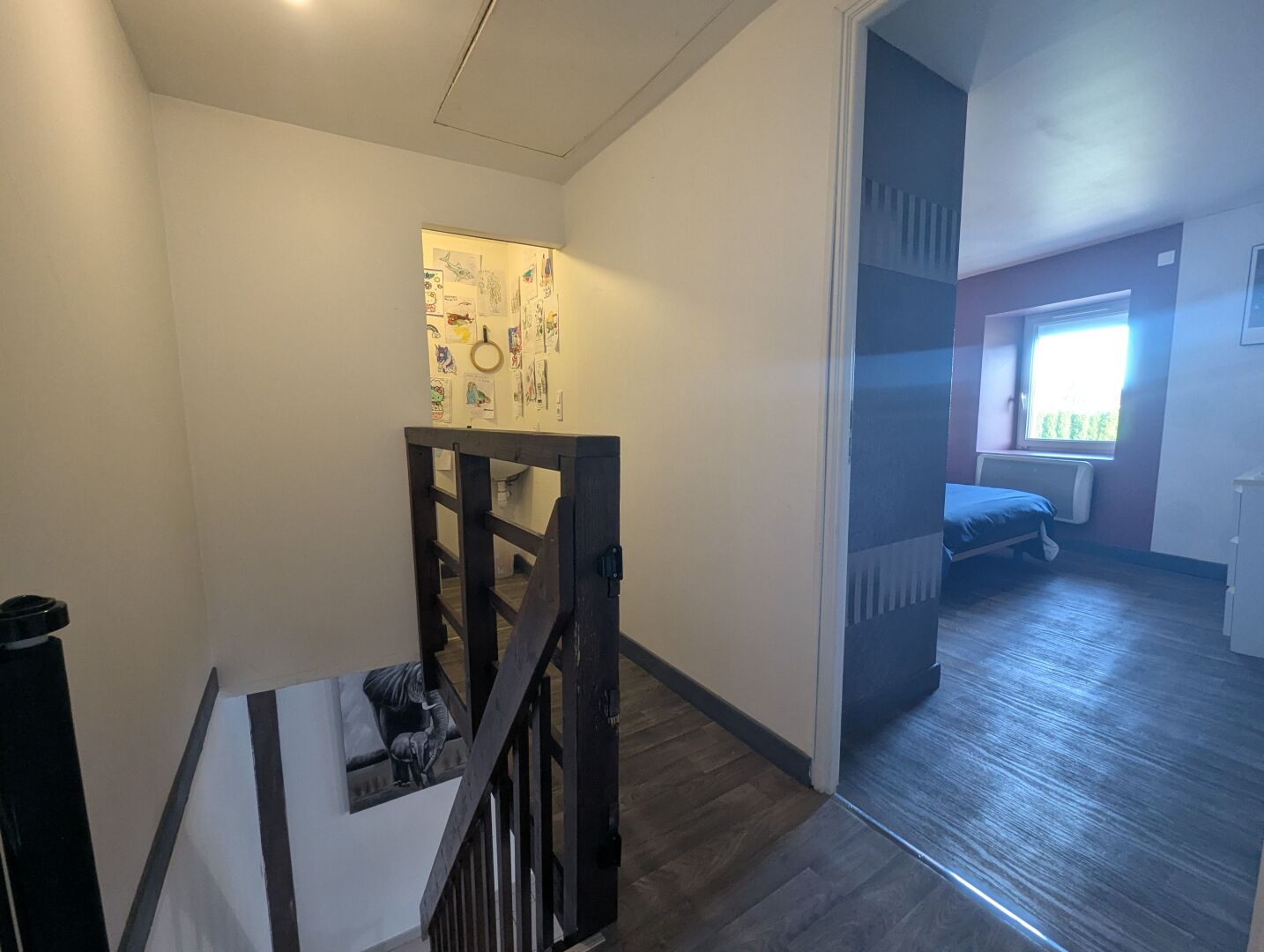 Escada que leva a um quarto com cama e janela.