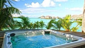 Tinaco con vista a bungalós sobre el agua y palmeras.