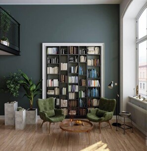 A room with a large bookshelf, two green armchairs, a round wooden coffee table, and a potted plant. - Charming 4-Bedroom Retreat in Carlton, VIC (Brisbane)