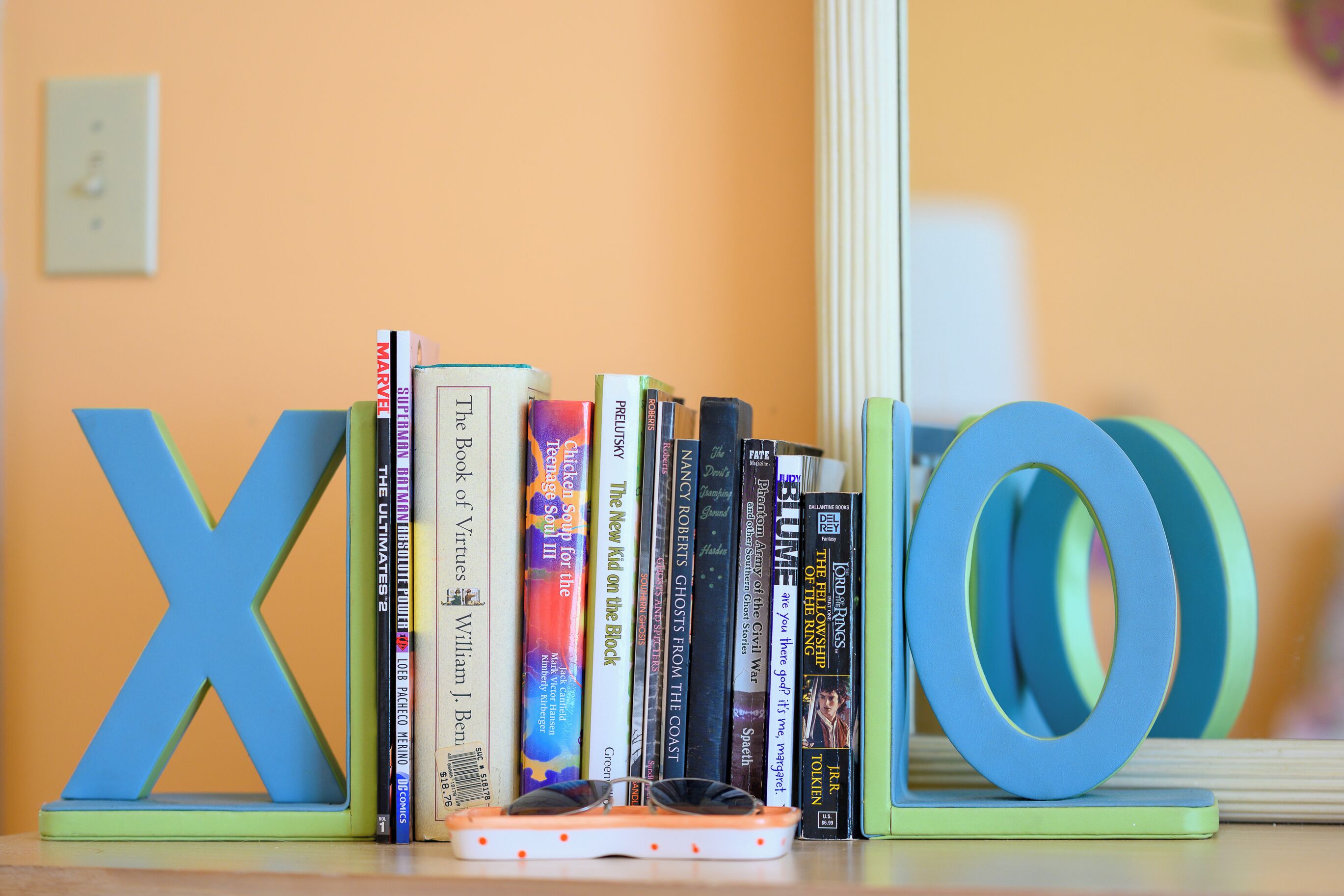 A bookshelf with books and alphabet letters.