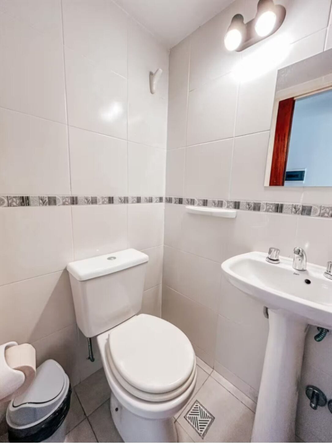 Une salle de bain équipée de toilettes, d’un bidet et d’un lavabo.