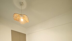 Una camera da letto moderna con un letto grande, una testiera in legno, un comodino con una lampada e un armadio.