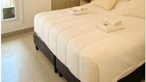 A bedroom with a bed, bedside table, lamp, and a wardrobe. - Dpto con excelente ubicación en Salta, Capital (Salta)