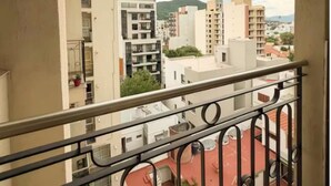A balcony with a metal railing, overlooking a cityscape with multiple buildings and a mountain in the distance. - Dpto con excelente ubicación en Salta, Capital (Salta)