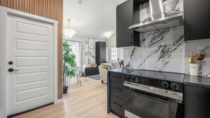 Une cuisine moderne équipée d’une cuisinière, d’un four et d’un dosseret en marbre.