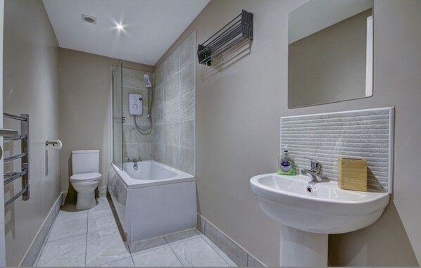 A bathroom with a toilet, shower, bathtub, sink, and a mirror. - Contractor Friendly 1-bed Ensuite Ayr Town Centre KA7 (Ayr)