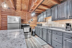 Eine moderne Küche mit Granit-Arbeitsplatten, Edelstahlgeräten und dunklen Schränken.