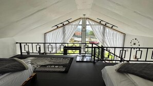 A room with two beds, a small table, and a view of the outside. - Cabin Athenea Sikapuk (Kejajar)