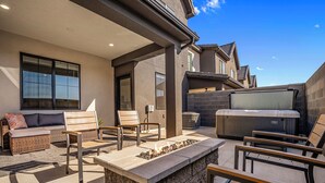 Patio esterno con focolare, posti a sedere e barbecue.