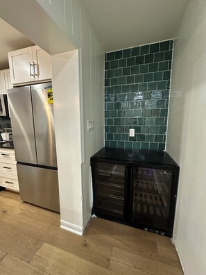 A kitchen with stainless steel appliances, a tiled backsplash, and a black refrigerator.