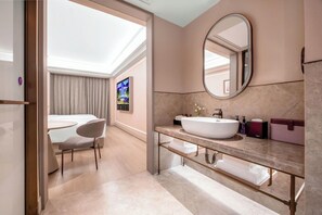A modern bathroom with a large oval mirror, a white sink, and a vanity with a marble countertop. - Mercure Chongqing Times Paradise Walk (Chongqing)