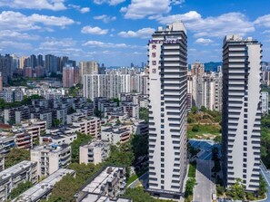 Un edificio de gran altura con varios pisos, rodeado de otros edificios residenciales.