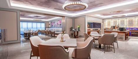 A spacious dining area with a high ceiling and modern lighting fixtures.