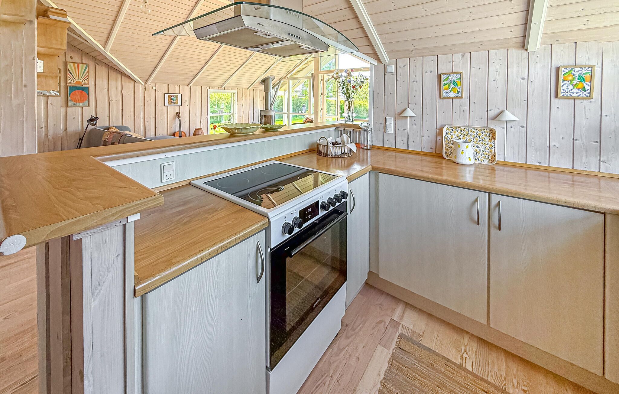 Une cuisine équipée d’une cuisinière, d’un four et de meubles de rangement en bois.