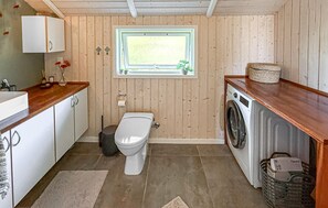 A compact kitchen with a washing machine, a toilet, and a window with a view. - Cozy home in Dannemare with WiFi (Dannemare)