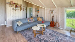 A cozy living room with a grey sectional sofa, a small round coffee table, and a patterned rug. - Cozy home in Dannemare with WiFi (Dannemare)