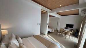 Ein modernes Hotelzimmer mit einem großen Bett, einem Schreibtisch und einem Fernseher.