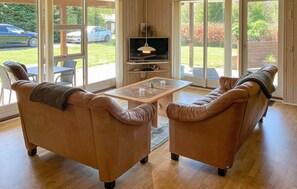 A living room with two leather sofas, a glass coffee table, and a television. - 4 bedroom gorgeous home in Farsø (Farsø)