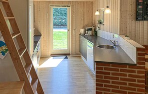 A modern kitchen with a wooden interior, a stainless steel sink, and a view of the outdoors. - 4 bedroom gorgeous home in Farsø (Farsø)