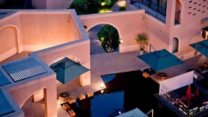Un hotel moderno con varias construcciones, piscinas exteriores y un patio bien iluminado.