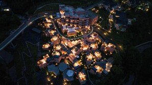 Vista aérea de una zona residencial con varias casas, un edificio central con cúpula y una carretera curva.