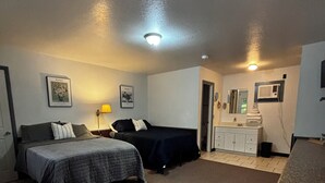 Un dormitorio con cama, escritorio y baño.