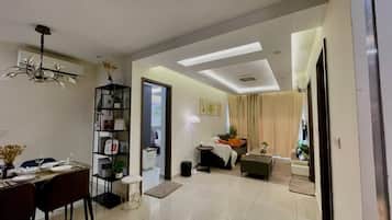 Habitación triple de lujo, balcón | Área de sala de estar | Smart TV de 45 pulgadas con canales por cable