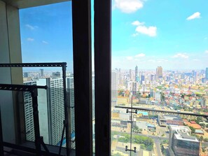 Um edifício alto com vista para o horizonte urbano através de amplas janelas.