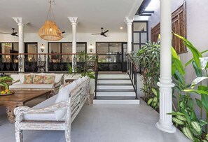 A spacious lobby with a staircase, seating area, and large windows. - 3BDR Villa Baruna, Good Location (Seminyak)