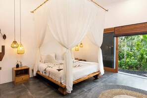 Ein Schlafzimmer mit Himmelbett, Nachttischen und Blick auf Grün durch eine Schiebetür.