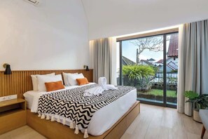Ein modernes Hotelzimmer mit einem großen Bett, einem Nachttisch, einem Fenster mit Vorhängen und Blick auf Grünfläche.