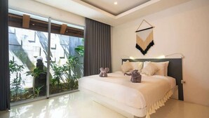 A modern bedroom with a large bed, a sliding glass door to a balcony, and a wall-mounted macrame piece. - Sweet Villa Love Umalas! Breakfast included (Umalas)