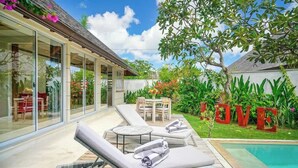 A modern outdoor lounge area with sun loungers and a pool. - Sweet Villa Love Umalas! Breakfast included (Umalas)