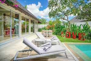 A modern outdoor lounge area with sun loungers and a pool. - Sweet Villa Love Umalas! Breakfast included (Umalas)