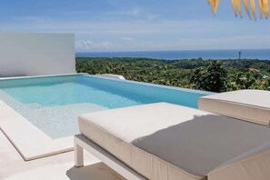 A pool with a clear view of the ocean and greenery in the background. - Villa Lola with Ocean View & Breakfast (Uluwatu)
