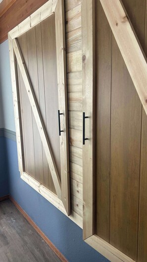 Ein Zimmer mit schrägem Dach, Holzwänden und einer blauen Akzentwand.
