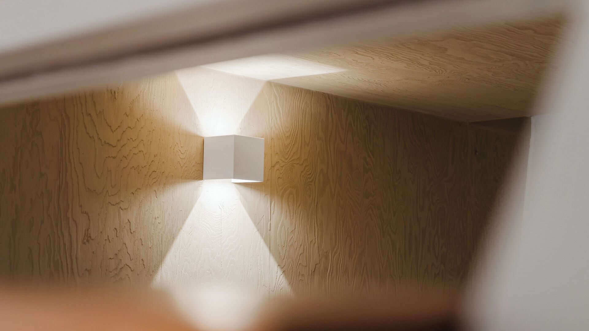 Una habitación con paredes de madera y una lámpara moderna.