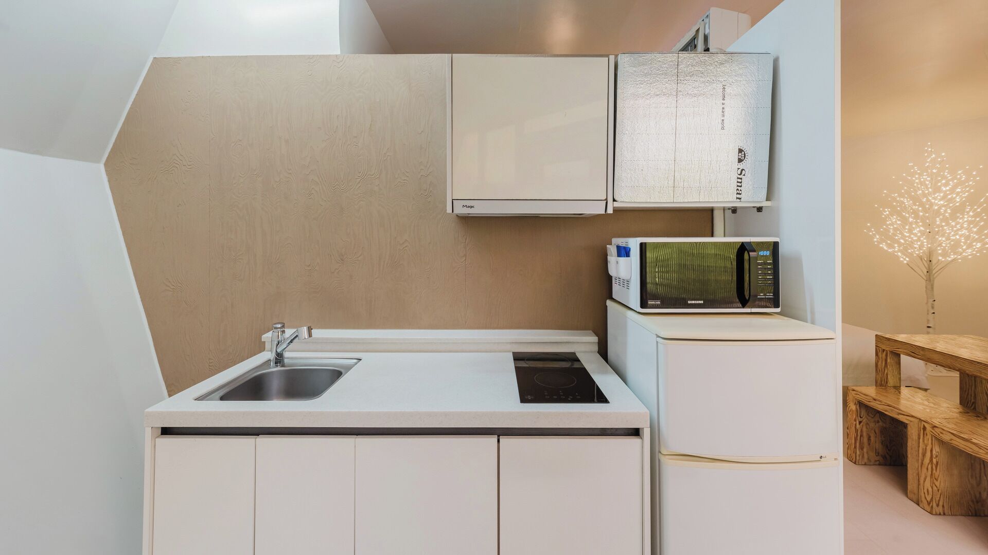 A compact kitchen with a sink, a microwave, and a cabinet.
