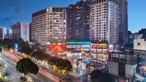 A multi-story hotel with a modern architectural design, featuring a prominent entrance and a large illuminated sign. - Yumi Apt Foshan Zumiao Metro Station (Foshan)