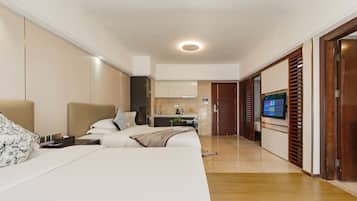 Ein modernes Hotelzimmer mit Bett, Schreibtisch, Fernseher und Badezimmer.