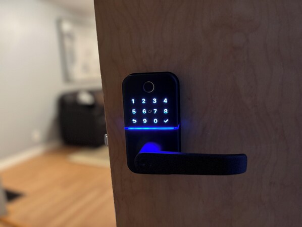 A keypad lock on a wooden door.