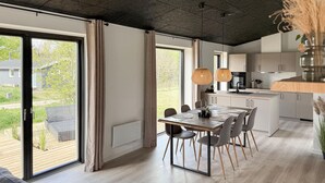 Una cocina moderna con comedor, ventanas amplias y vistas al exterior.