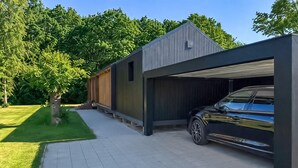 A modern building with a garage and a parked car. - Lovely home in Sunds with WiFi (Sunds)