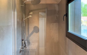 A shower with a handheld showerhead, a wall-mounted faucet, and a window with a view of a building outside. - Lovely home in Sunds with WiFi (Sunds)