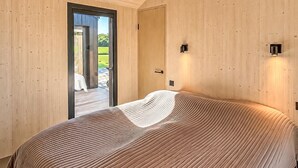 A bedroom with a bed, a door, and a view of a patio. - Lovely home in Sunds with WiFi (Sunds)