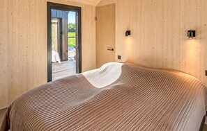 A bedroom with a bed, a door, and a view of a patio. - Lovely home in Sunds with WiFi (Sunds)