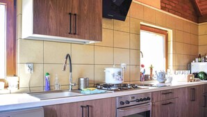 Une cuisine avec des meubles en bois, une cuisinière à gaz, un four à micro-ondes et un lave-vaisselle.