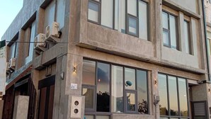 Um edifício moderno com janelas amplas, telhado plano e fachada de concreto.