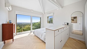 A bedroom with a bed, a dresser, a large mirror, and a view through a sliding glass door. - Air-conditioned dream villa with lagoon-style pool and sea view for 6 guests in La Londe-les-Maures (LA LONDE LES MAURES)