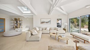 A modern living room with a sectional sofa, a round coffee table, a chaise lounge, and a bookshelf. - Air-conditioned dream villa with lagoon-style pool and sea view for 6 guests in La Londe-les-Maures (LA LONDE LES MAURES)